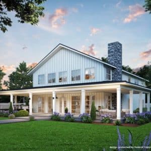 White barndominium with wraparound porch and flowers lining the porch