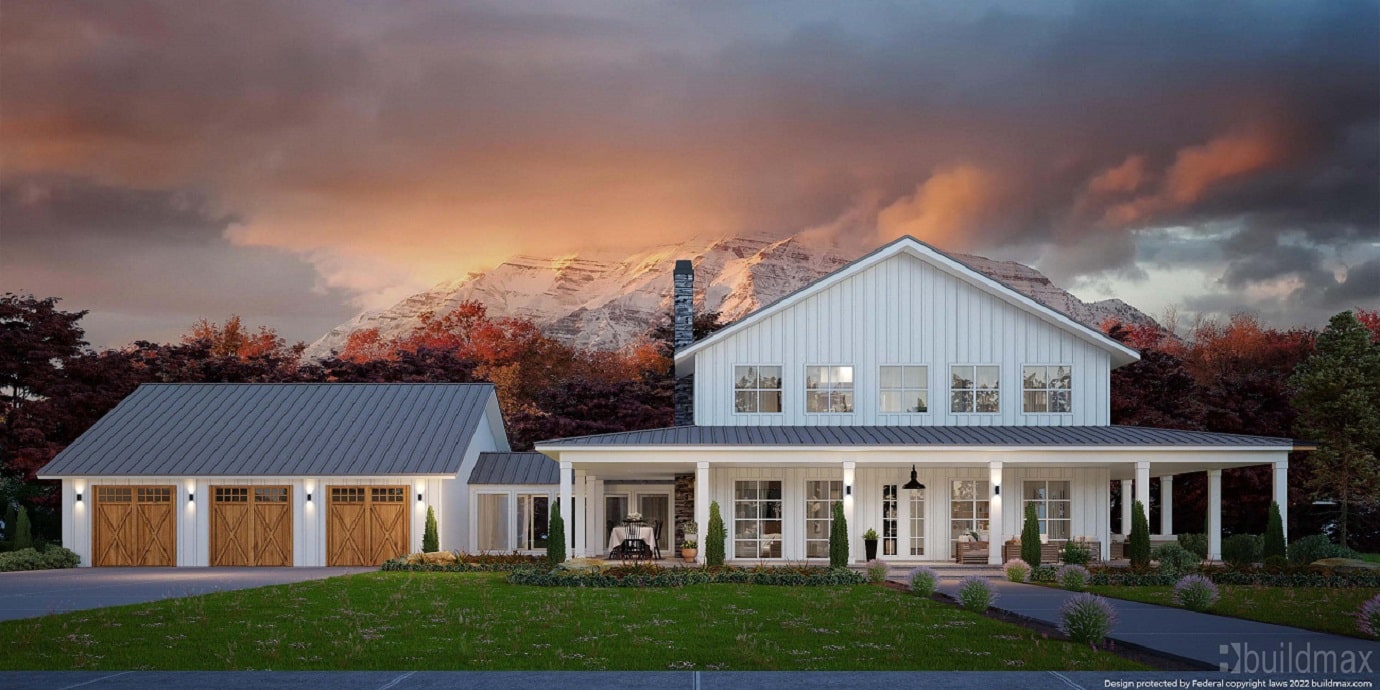 White barndominium with 3 car garage, wraparound porch, and mountains in the background