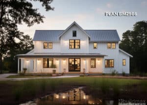 white barndominium with wraparound porch by the lake